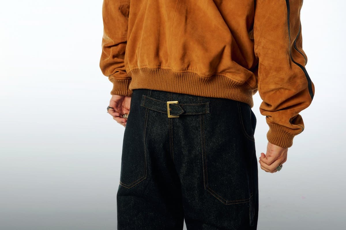 The Suede Warm-Up Jacket from behind over the Sailor Utility Denim, showing the brass cinch buckle at the back waist