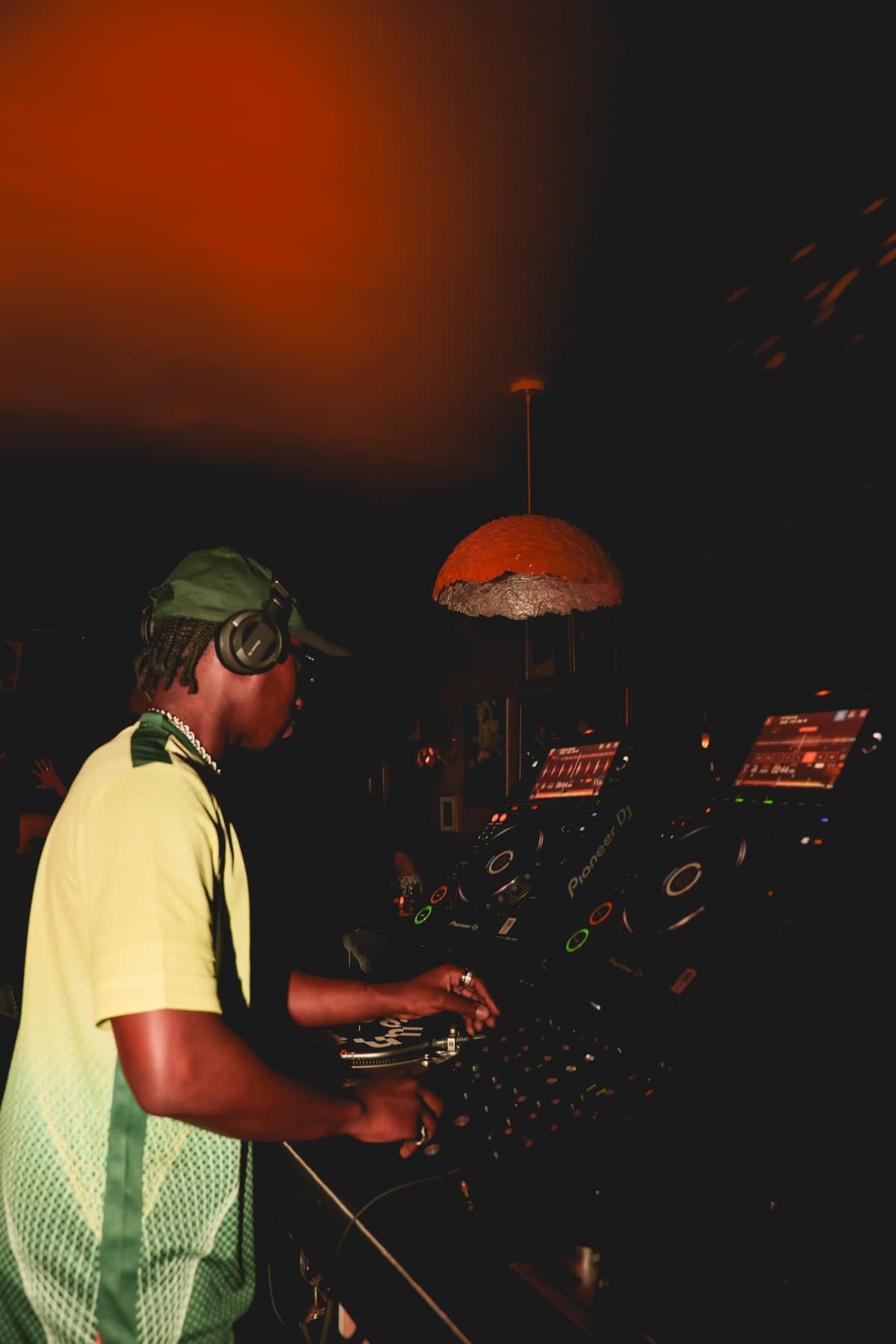 A DJ in the booth at a Skirtts Sounds night, red light overhead